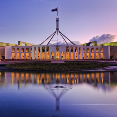 colourful reflection of Canberra's new parliament building in a fontain pond at sunset.